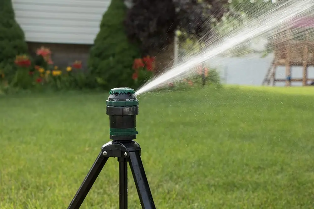 Sprinkler statiivil paigaldatud aias