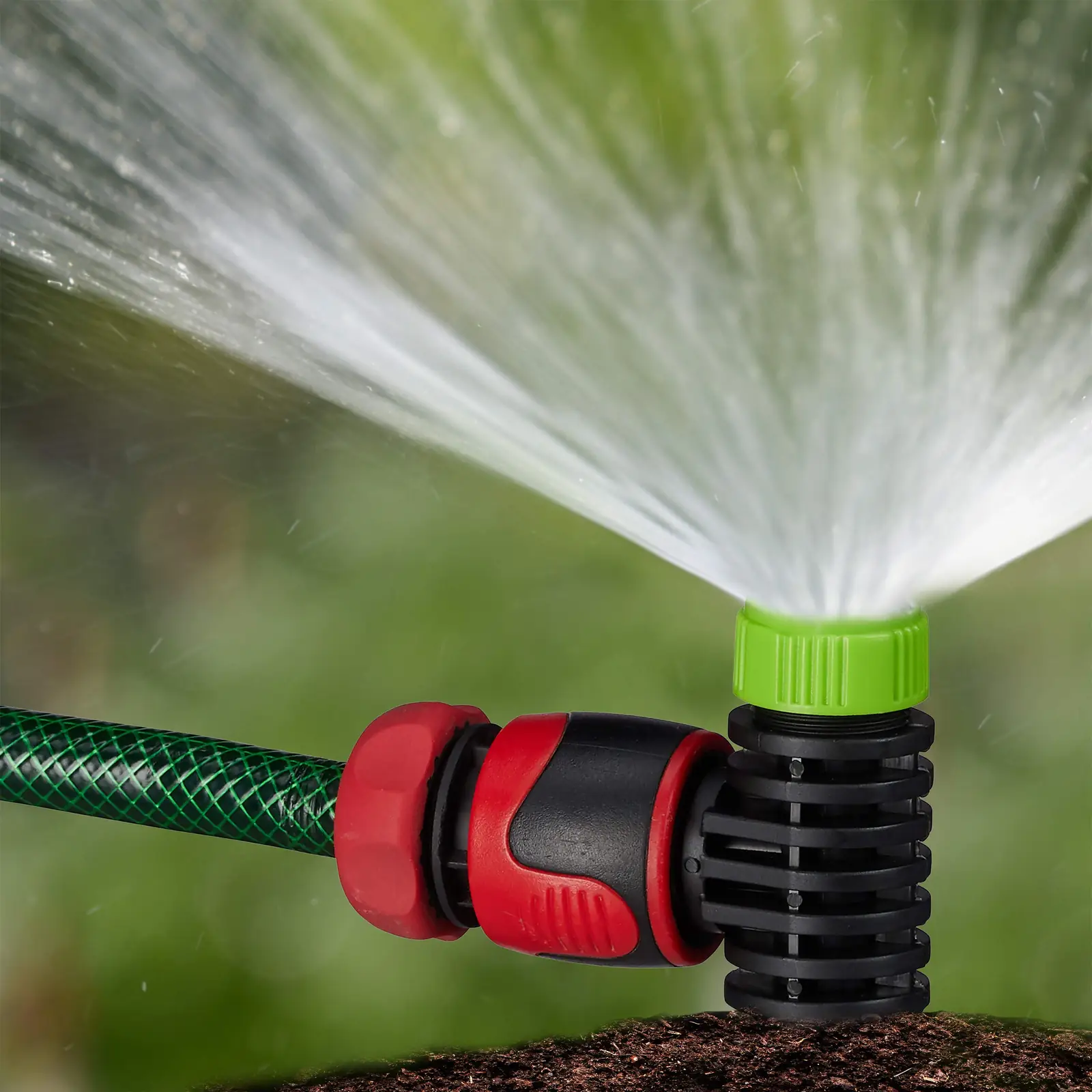 Sprinkler koos maasse kinnitatava piigiga rohu peal